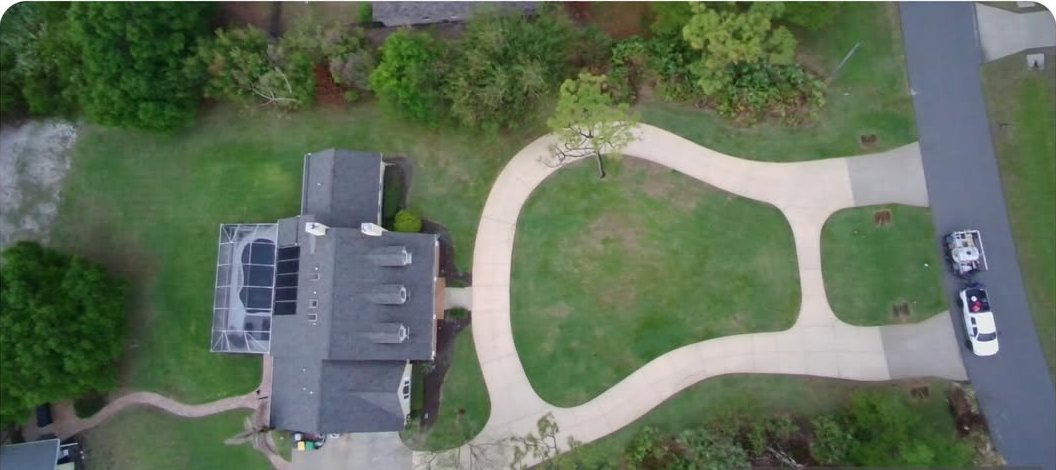Aerial view of a long concrete driveway after cleaning in Brevard County